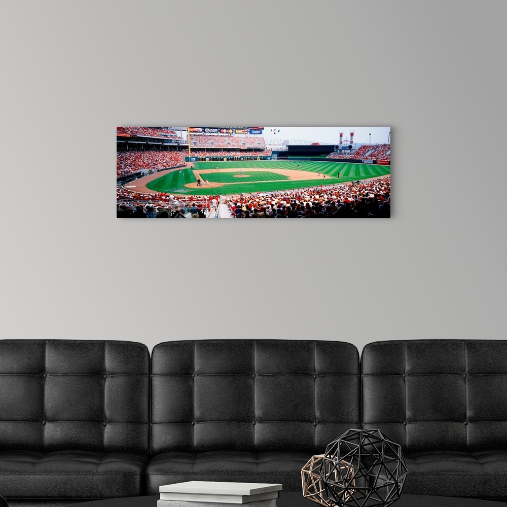 A modern room featuring A crowded baseball stadium photograph from near home plate on a panoramic canvas.