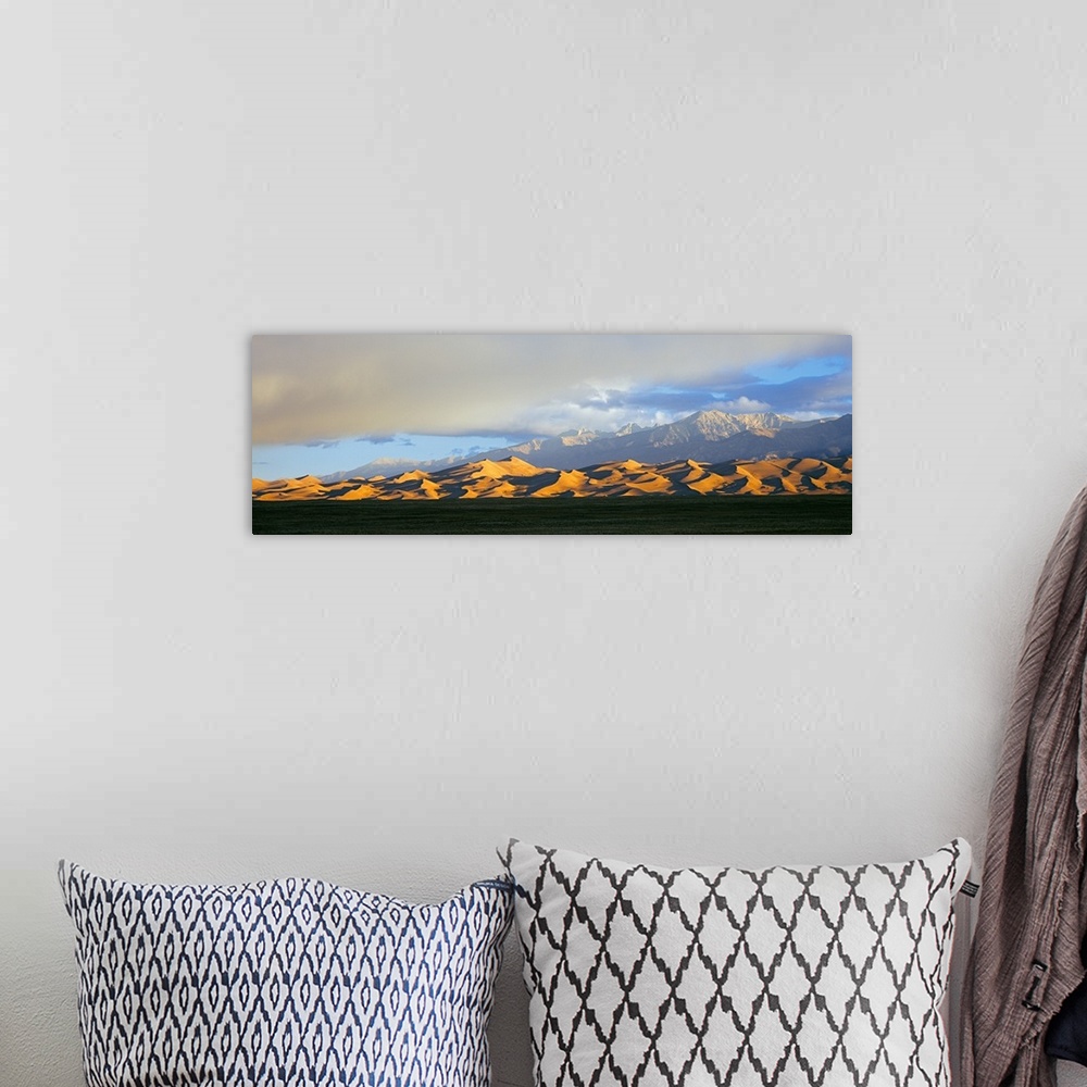 A bohemian room featuring Sand dunes in a desert with a mountain range in the background, Great Sand Dunes National Park, C...
