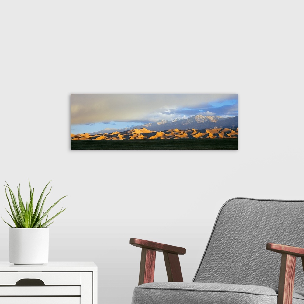 A modern room featuring Sand dunes in a desert with a mountain range in the background, Great Sand Dunes National Park, C...
