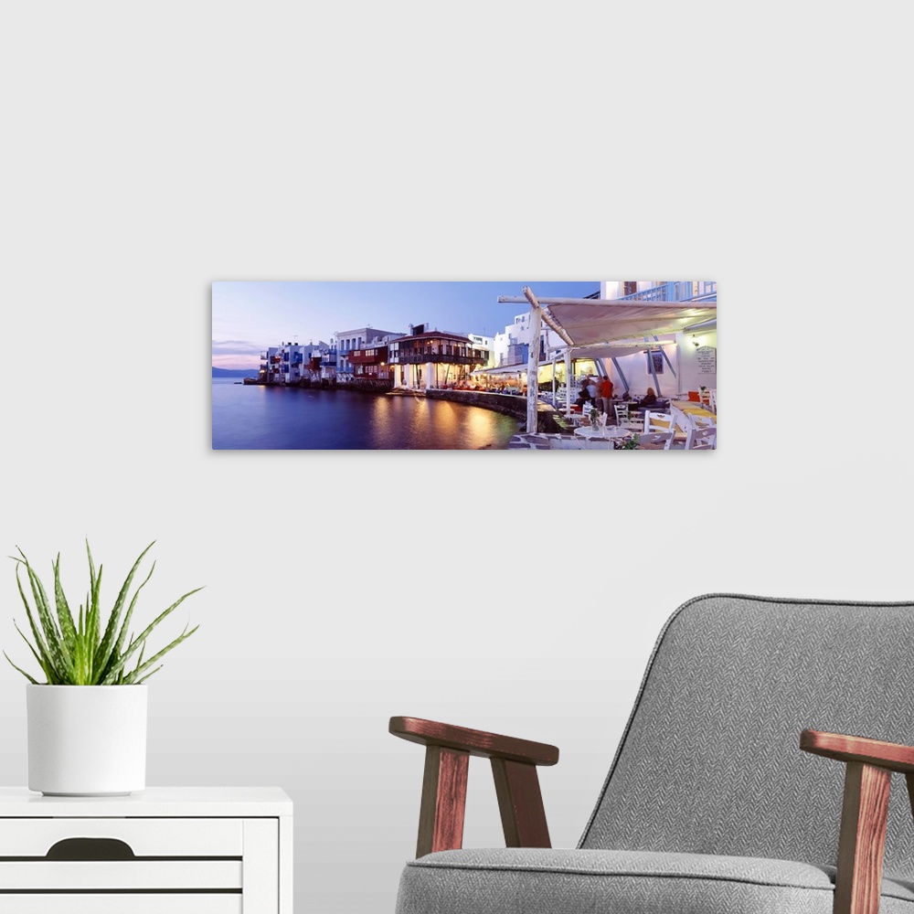A modern room featuring Panoramic photograph displays a busy shoreline filled with restaurants and buildings as their bri...