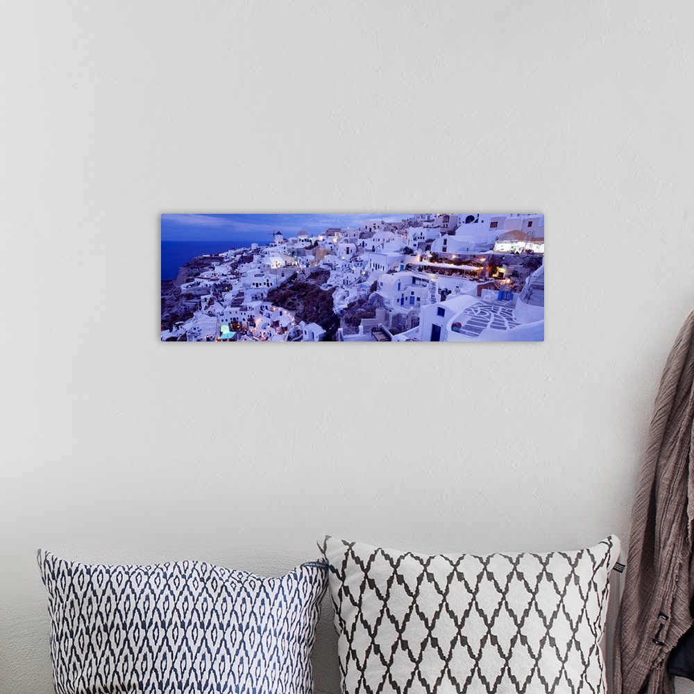 A bohemian room featuring Long horizontal image on canvas of a city on the side of a mountain overlooking the ocean in Greece.