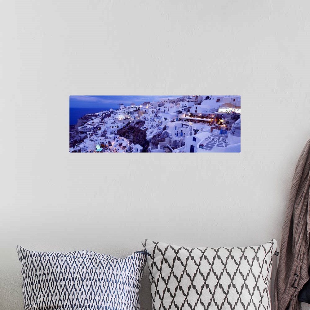A bohemian room featuring Long horizontal image on canvas of a city on the side of a mountain overlooking the ocean in Greece.