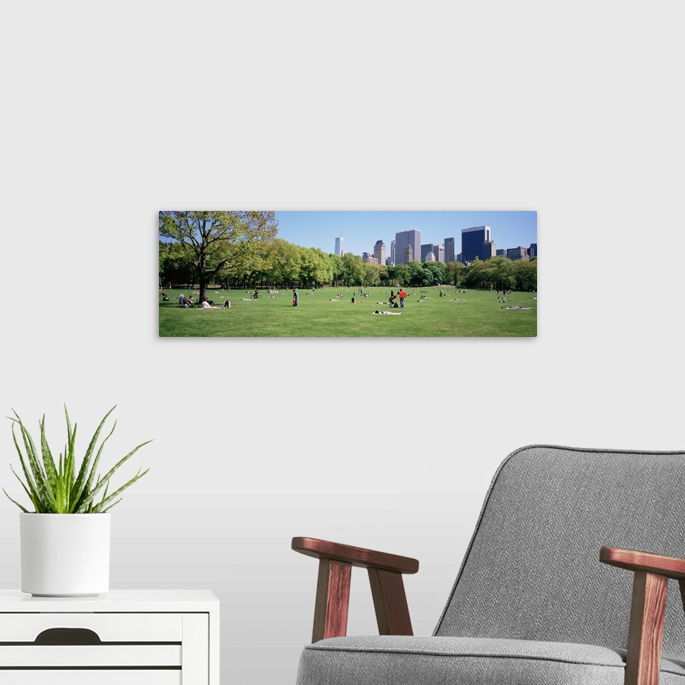 A modern room featuring Panoramic view of central park with people relaxing and enjoying the downtown skyline.