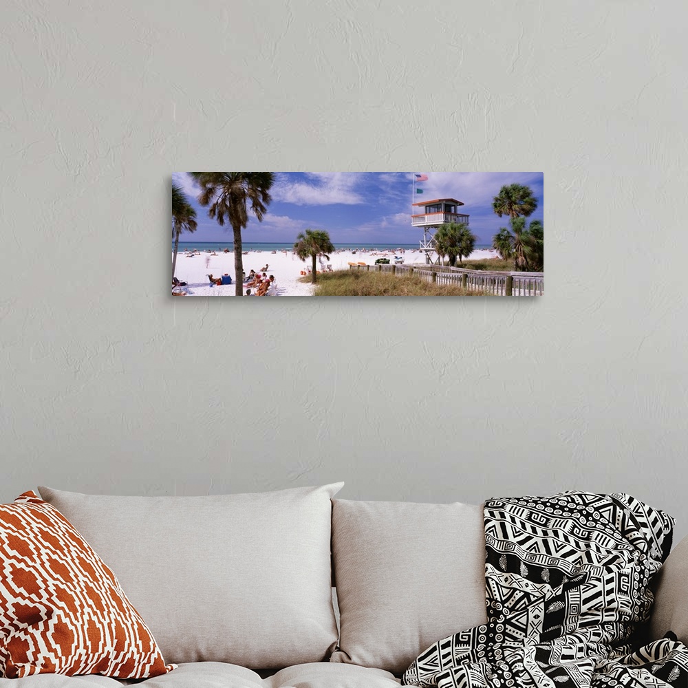 A bohemian room featuring Panoramic print of a crowded beach with a lifeguard stand and palm trees.