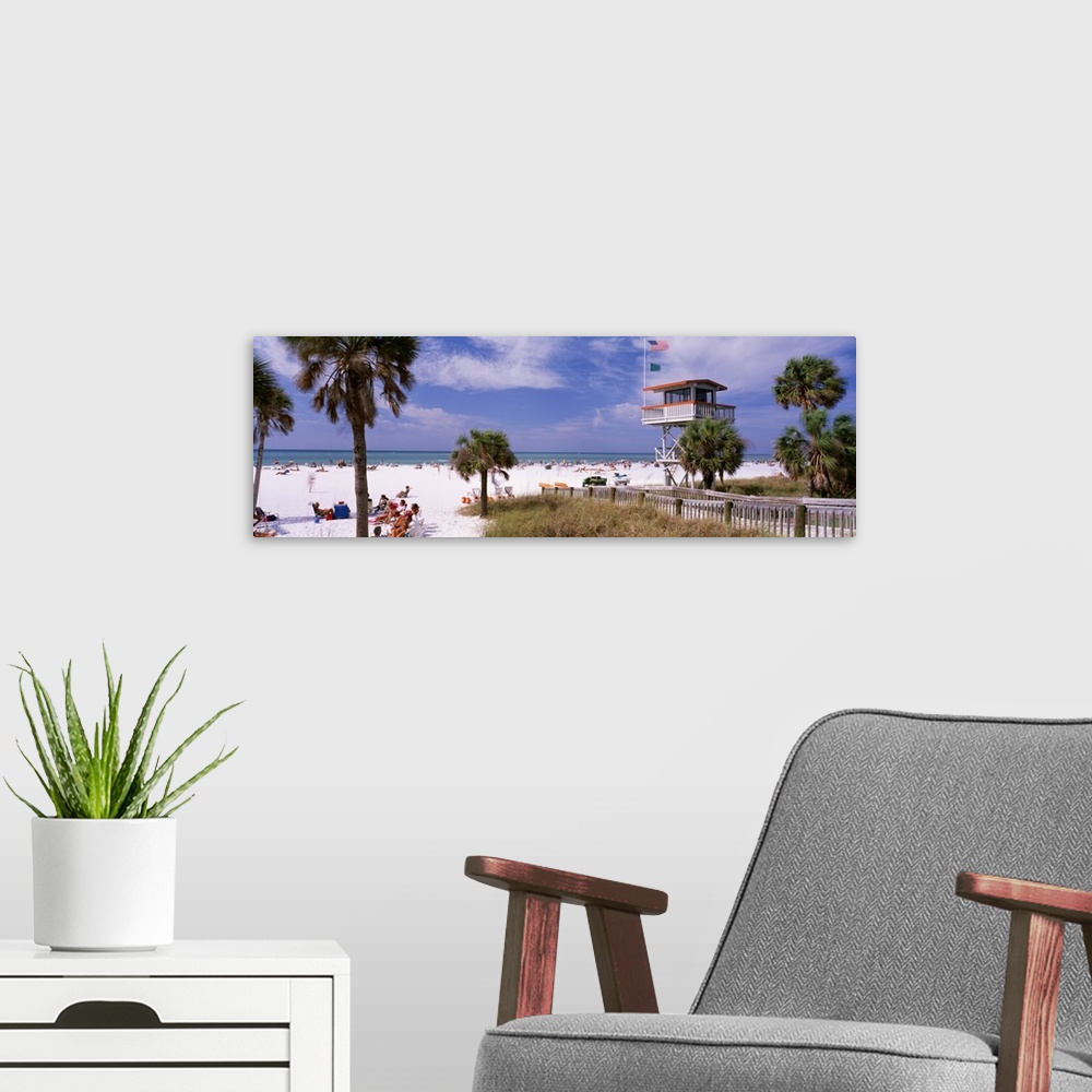 A modern room featuring Panoramic print of a crowded beach with a lifeguard stand and palm trees.
