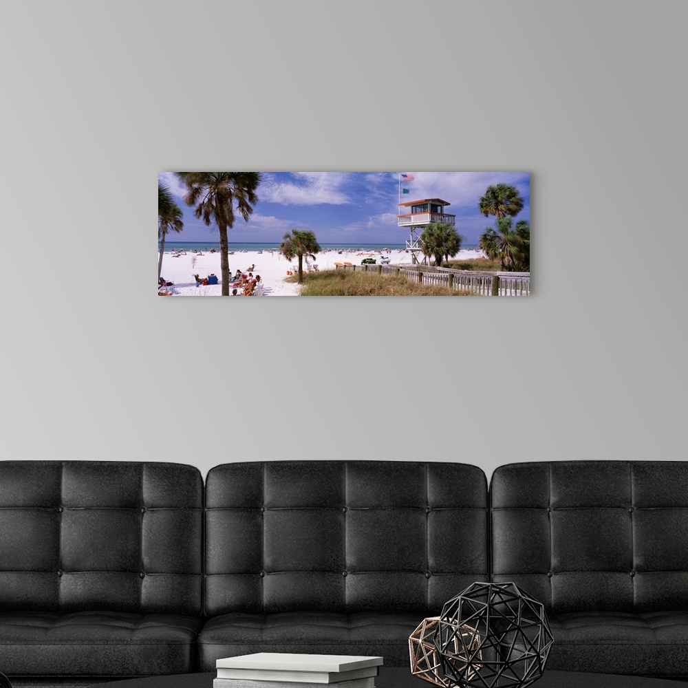 A modern room featuring Panoramic print of a crowded beach with a lifeguard stand and palm trees.