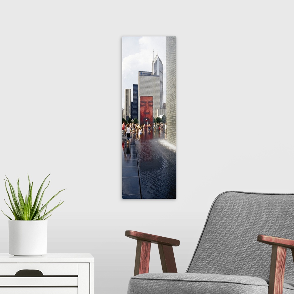 A modern room featuring Oversized vertical photograph of a large group of people surrounding Crown Fountain in Chicago's ...