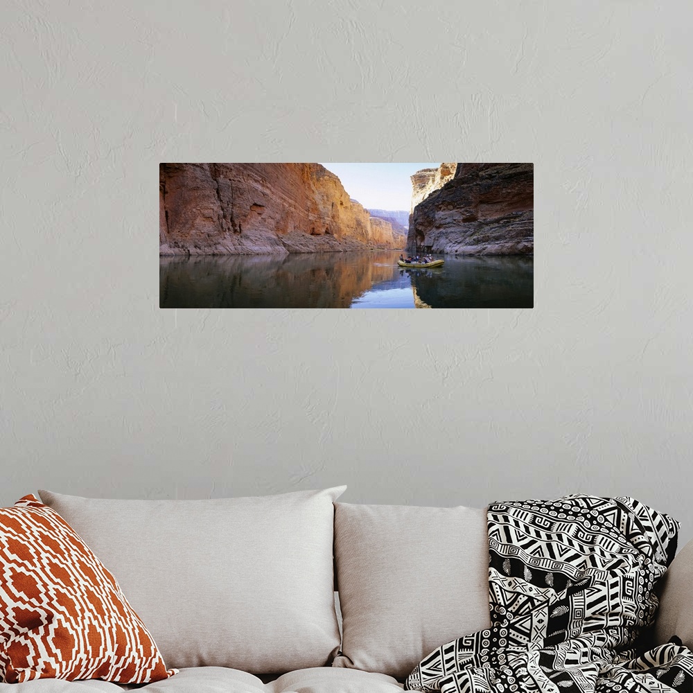 A bohemian room featuring Large panoramic shot of an inflatable raft drifting down the tranquil Colorado River in the Grand...