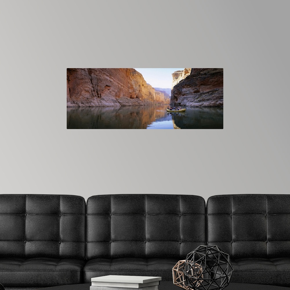 A modern room featuring Large panoramic shot of an inflatable raft drifting down the tranquil Colorado River in the Grand...