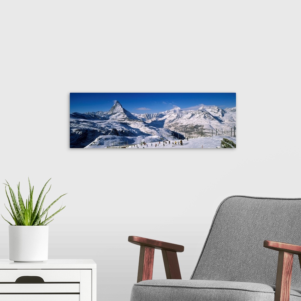 A modern room featuring Group of people skiing near a snow covered mountain, Matterhorn, Switzerland