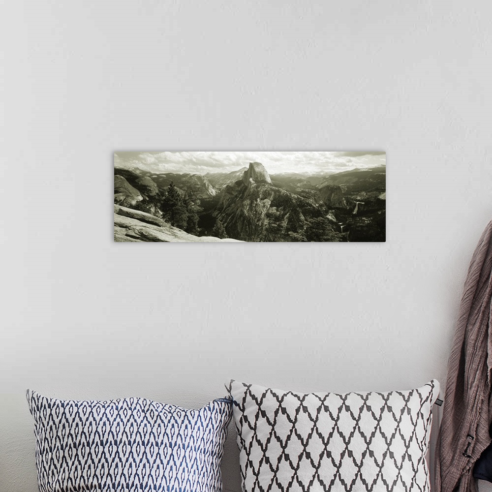 A bohemian room featuring Panoramic photograph of mountain range under a cloudy sky with cliff's edge in foreground.