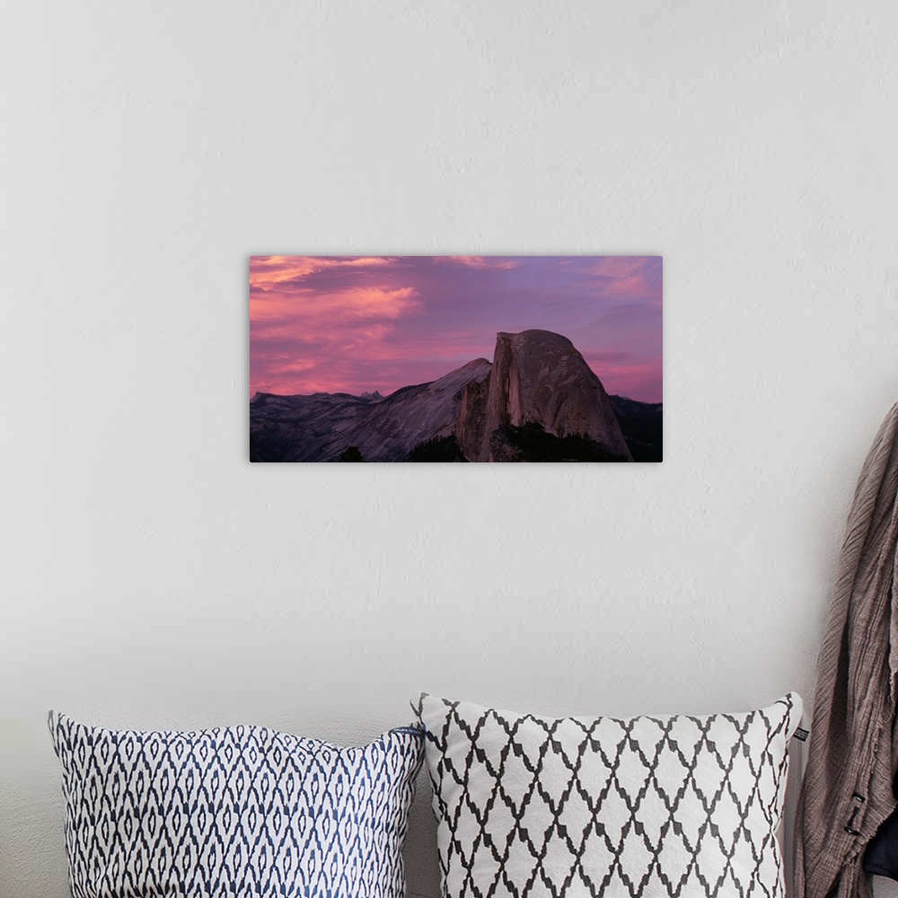 A bohemian room featuring Photograph of huge rock formation under a dark cloudy sky.