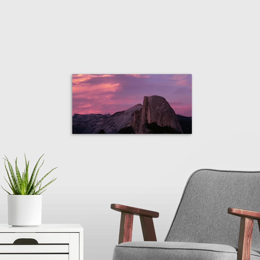 A modern room featuring Photograph of huge rock formation under a dark cloudy sky.