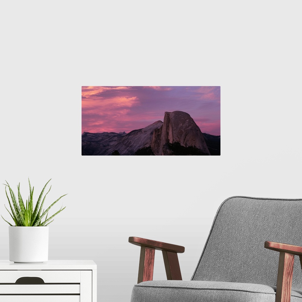 A modern room featuring Photograph of huge rock formation under a dark cloudy sky.