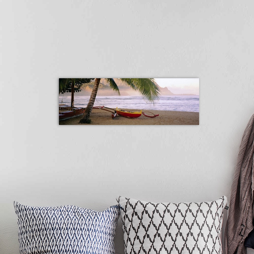 A bohemian room featuring Panoramic photograph shows a boat sitting beneath a palm tree on the sandy shores of a beach in t...