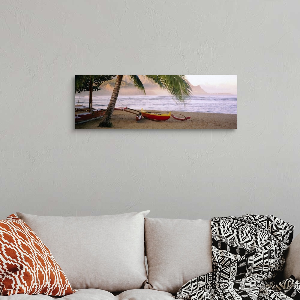 A bohemian room featuring Panoramic photograph shows a boat sitting beneath a palm tree on the sandy shores of a beach in t...