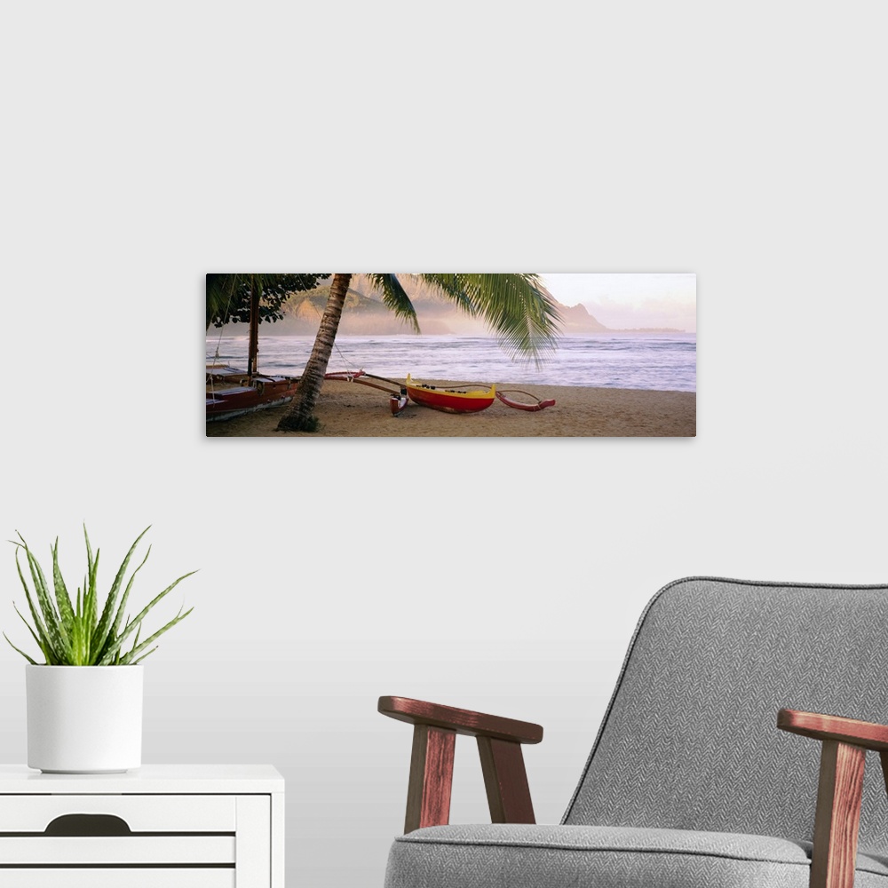 A modern room featuring Panoramic photograph shows a boat sitting beneath a palm tree on the sandy shores of a beach in t...
