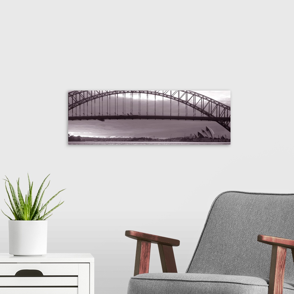 A modern room featuring Panoramic photo on canvas of a long bridge over water in Sydney with the Opera House in the lower...