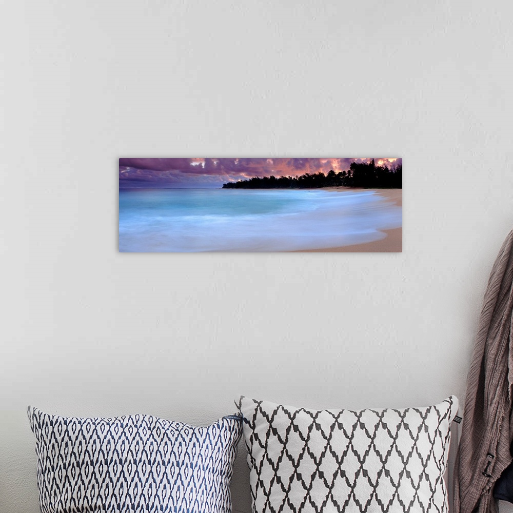 A bohemian room featuring A time lapsed photograph of waves lapping against a sandy tropical beach with the silhouetted of ...