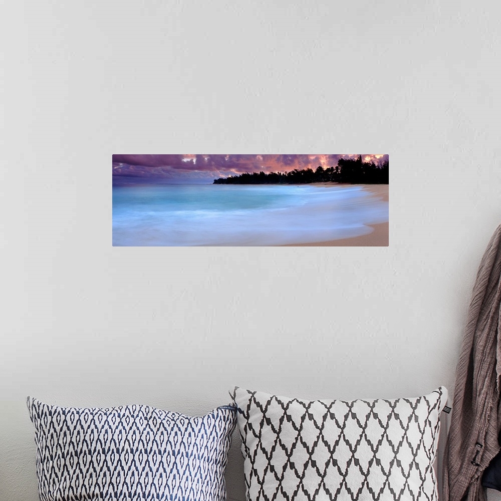 A bohemian room featuring A time lapsed photograph of waves lapping against a sandy tropical beach with the silhouetted of ...