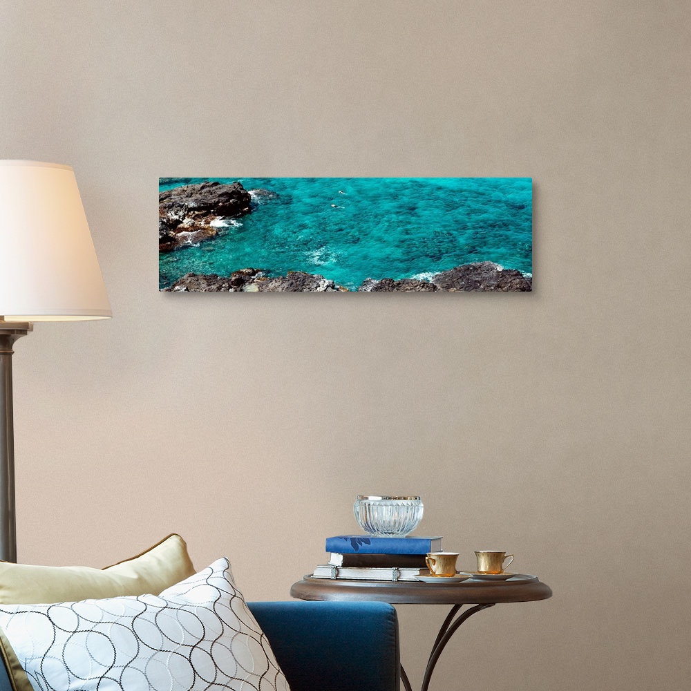 A traditional room featuring This panoramic photograph shows two figures from distance in clear waters of a reef.