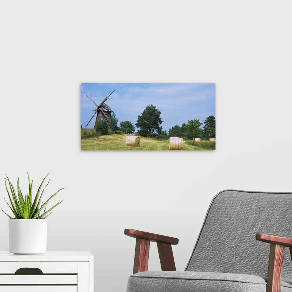 A modern room featuring Hay bale in a field with a traditional windmill in the background, Riddarfjarden, Narke, Sweden