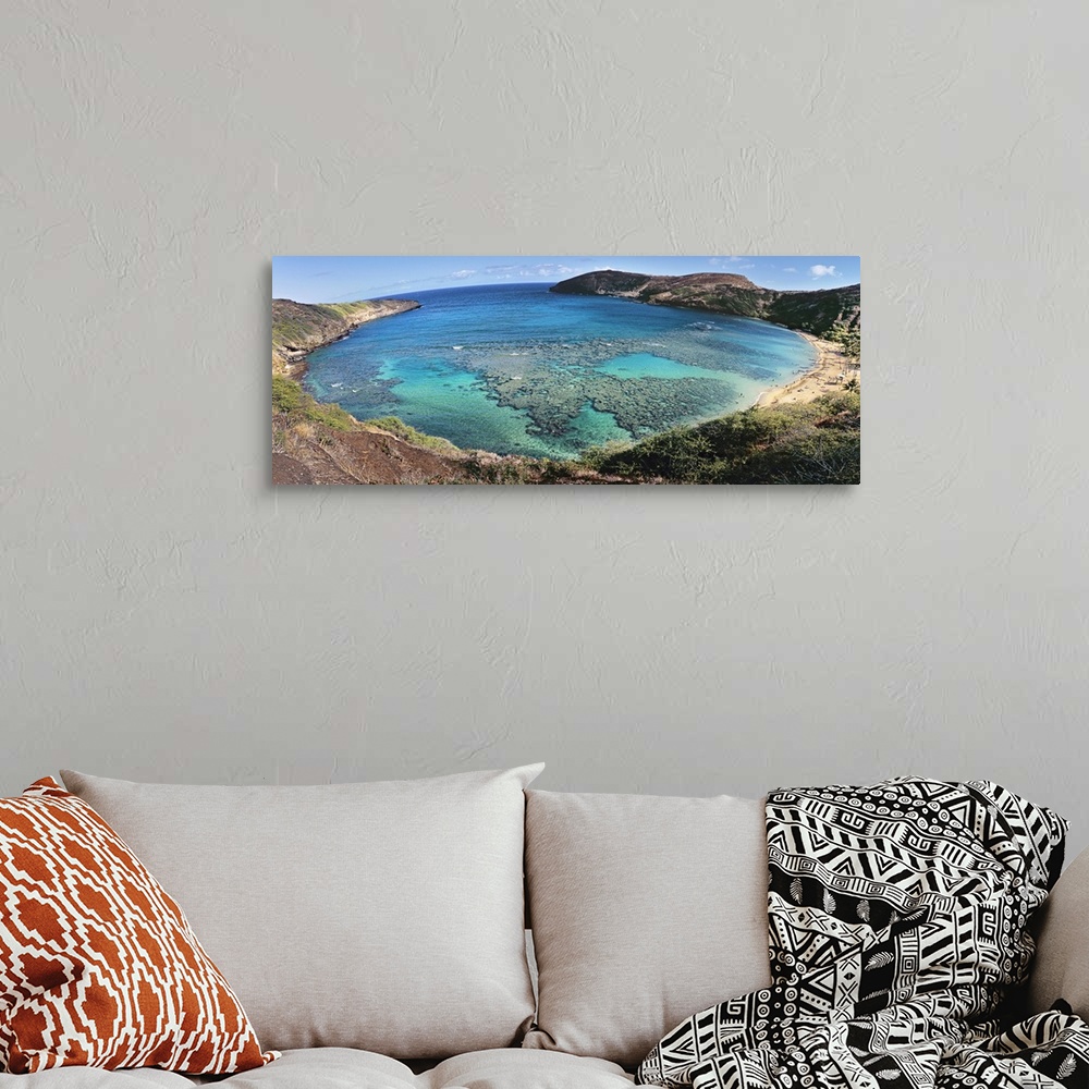 A bohemian room featuring Panoramic photograph of gulf surrounded by beach and mountainsides.