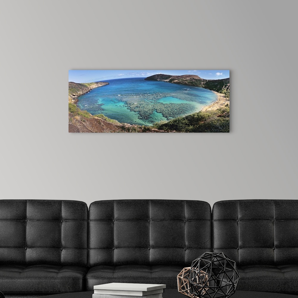 A modern room featuring Panoramic photograph of gulf surrounded by beach and mountainsides.