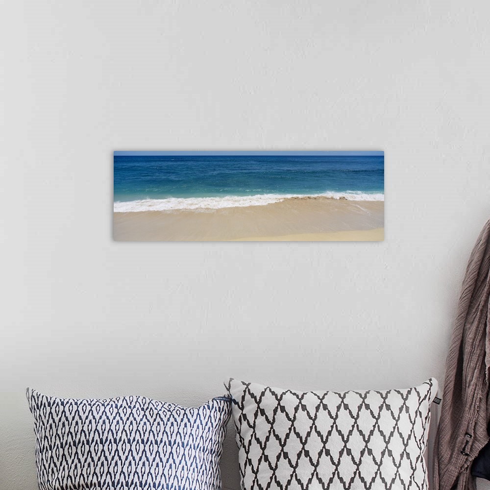 A bohemian room featuring Long photograph of waves crashing in to the sandy beach as blue water stretches for miles in the ...