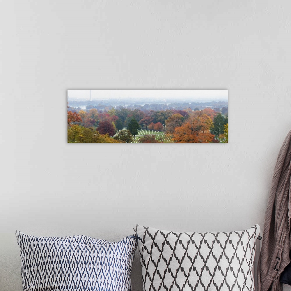 A bohemian room featuring An ariel photograph of Arlington National Cemetery surrounded by autumn colored trees and a view ...
