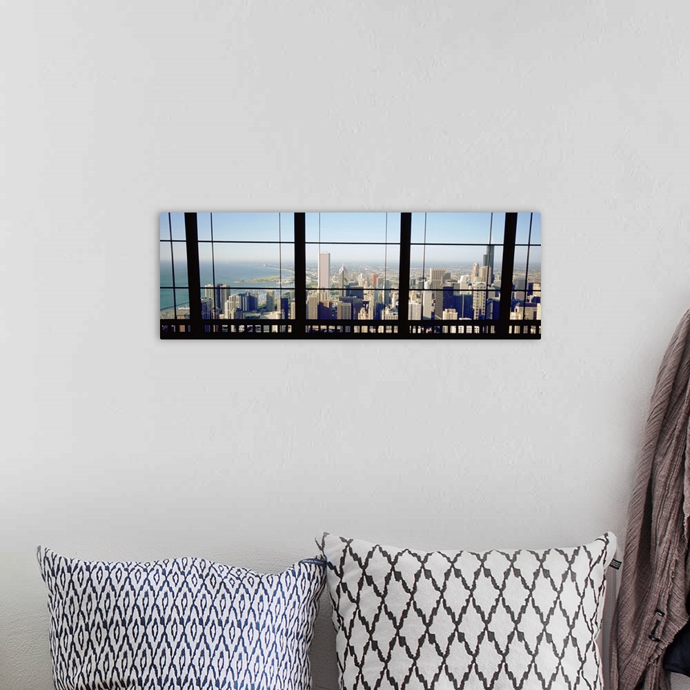 A bohemian room featuring Panoramic photograph of skyline and waterfront from behind a window.