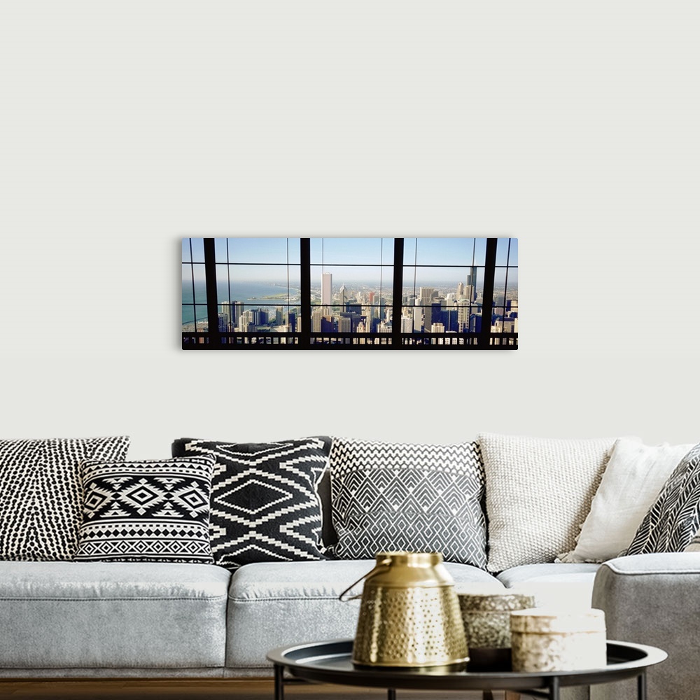 A bohemian room featuring Panoramic photograph of skyline and waterfront from behind a window.