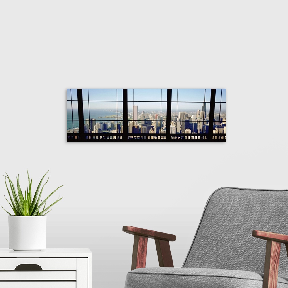 A modern room featuring Panoramic photograph of skyline and waterfront from behind a window.