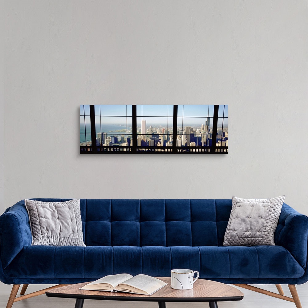 A modern room featuring Panoramic photograph of skyline and waterfront from behind a window.