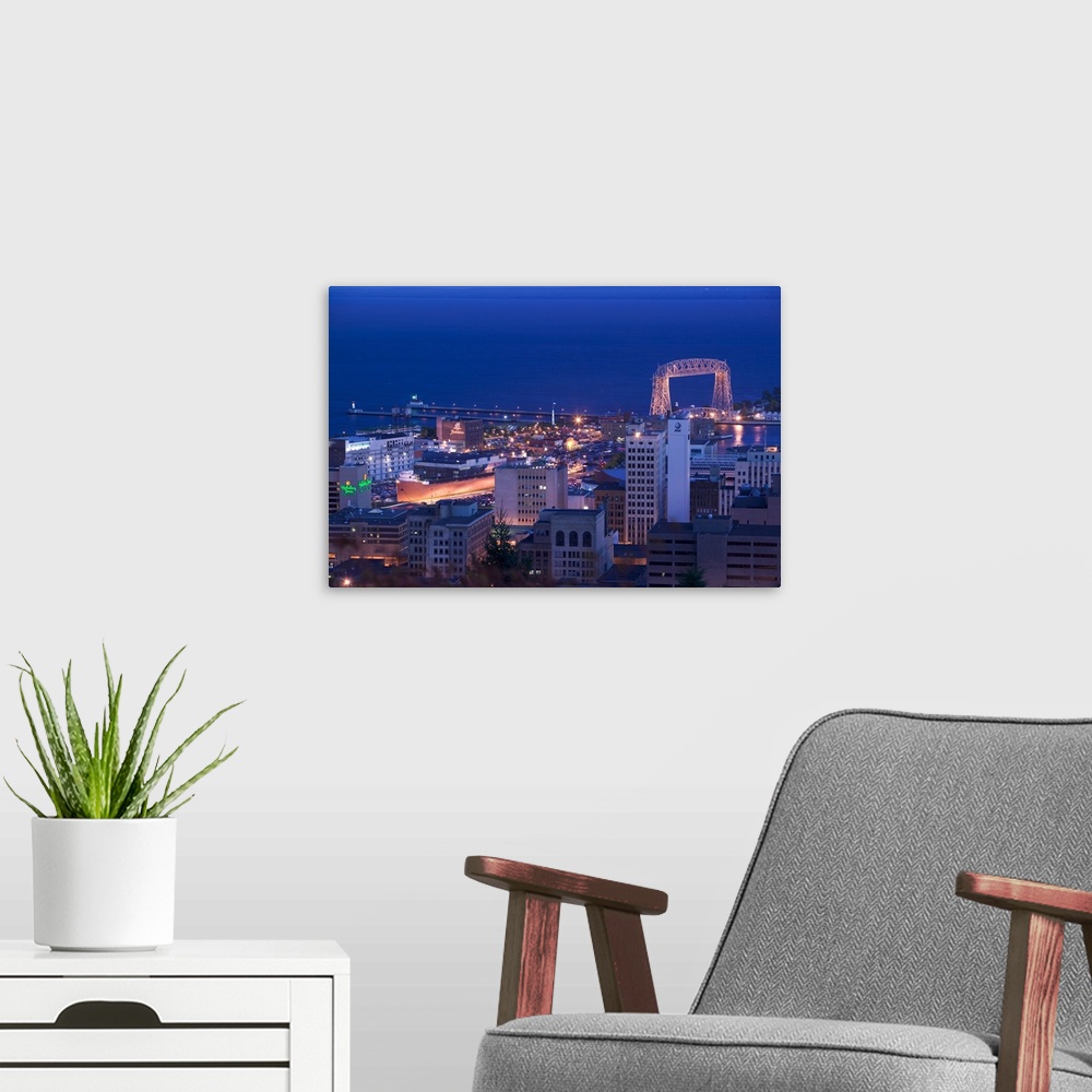 A modern room featuring This wall art for the office or home is an aerial photograph of city harbor at night.