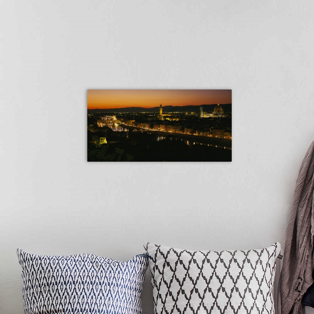 A bohemian room featuring Panoramic photograph of lit up skyline with mountain silhouettes in the distance at sunset.