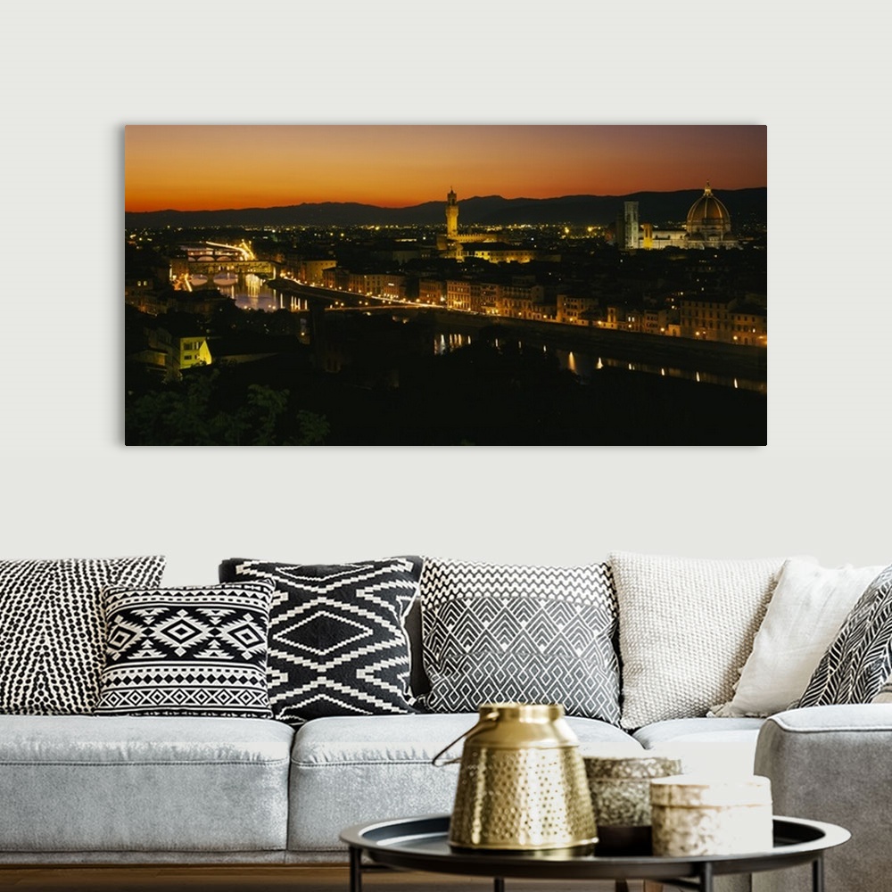 A bohemian room featuring Panoramic photograph of lit up skyline with mountain silhouettes in the distance at sunset.