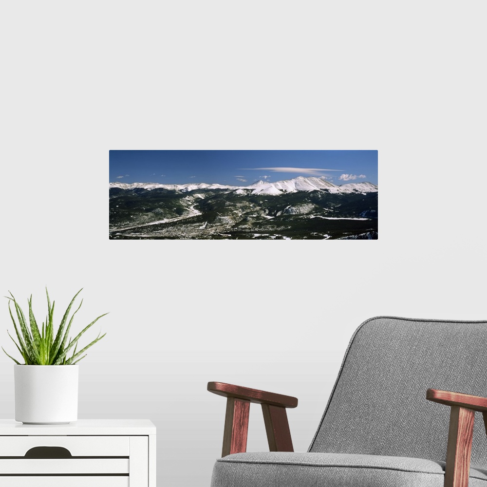 A modern room featuring This wide angle photograph is an aerial shot of a snow covered mountain range with vast land and ...