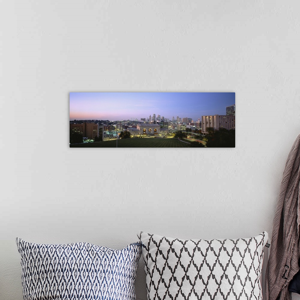 A bohemian room featuring Wide angle photograph taken of the Kansas City skyline with the buildings illuminated under a dus...