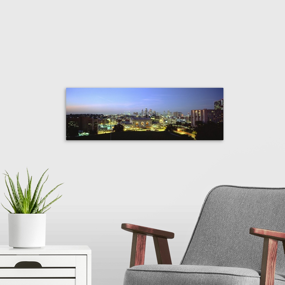 A modern room featuring Large panoramic image of a downtown cityscape in Missouri lit up at night.