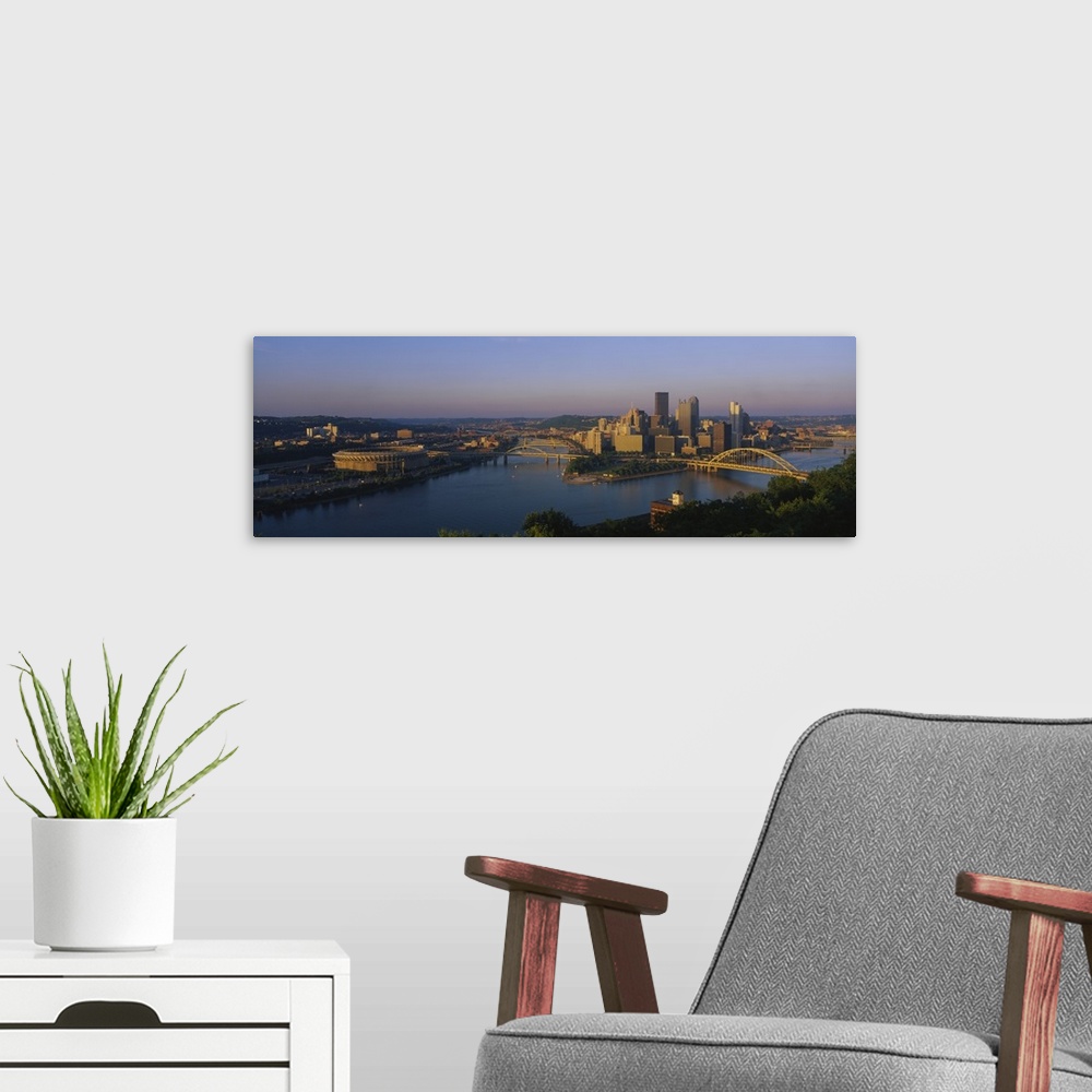 A modern room featuring Panoramic photo of the Pittsburgh skyline bathed in morning light, showing skyscrapers and two br...