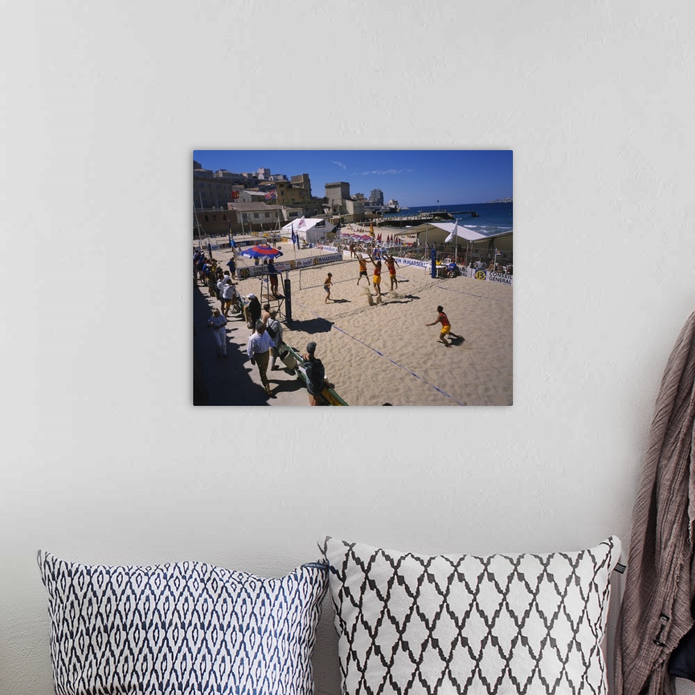 A bohemian room featuring High angle view of a group of men playing volleyball on the beach, Plage des Catalans, Marseille,...