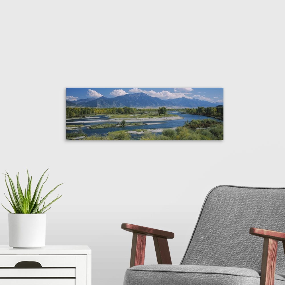A modern room featuring Big wall panoramic wall docor of a river leading into a bigger body of water and mountains encase...