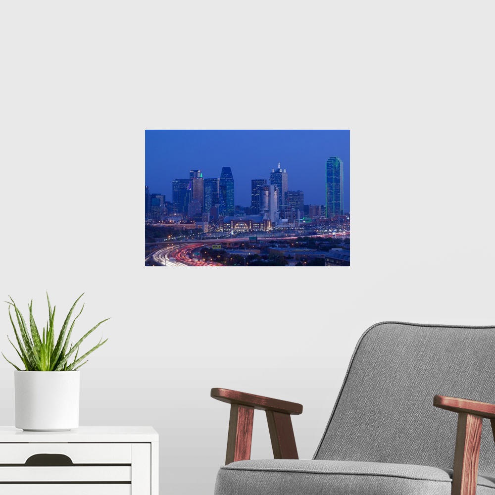 A modern room featuring Big photograph of downtown Dallas, Texas (TX) at night with a busy road in the foreground in fron...