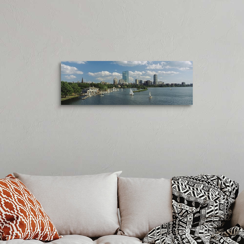 A bohemian room featuring A panoramic photograph of Charles river with sail boats and the Boston skyline in the background....