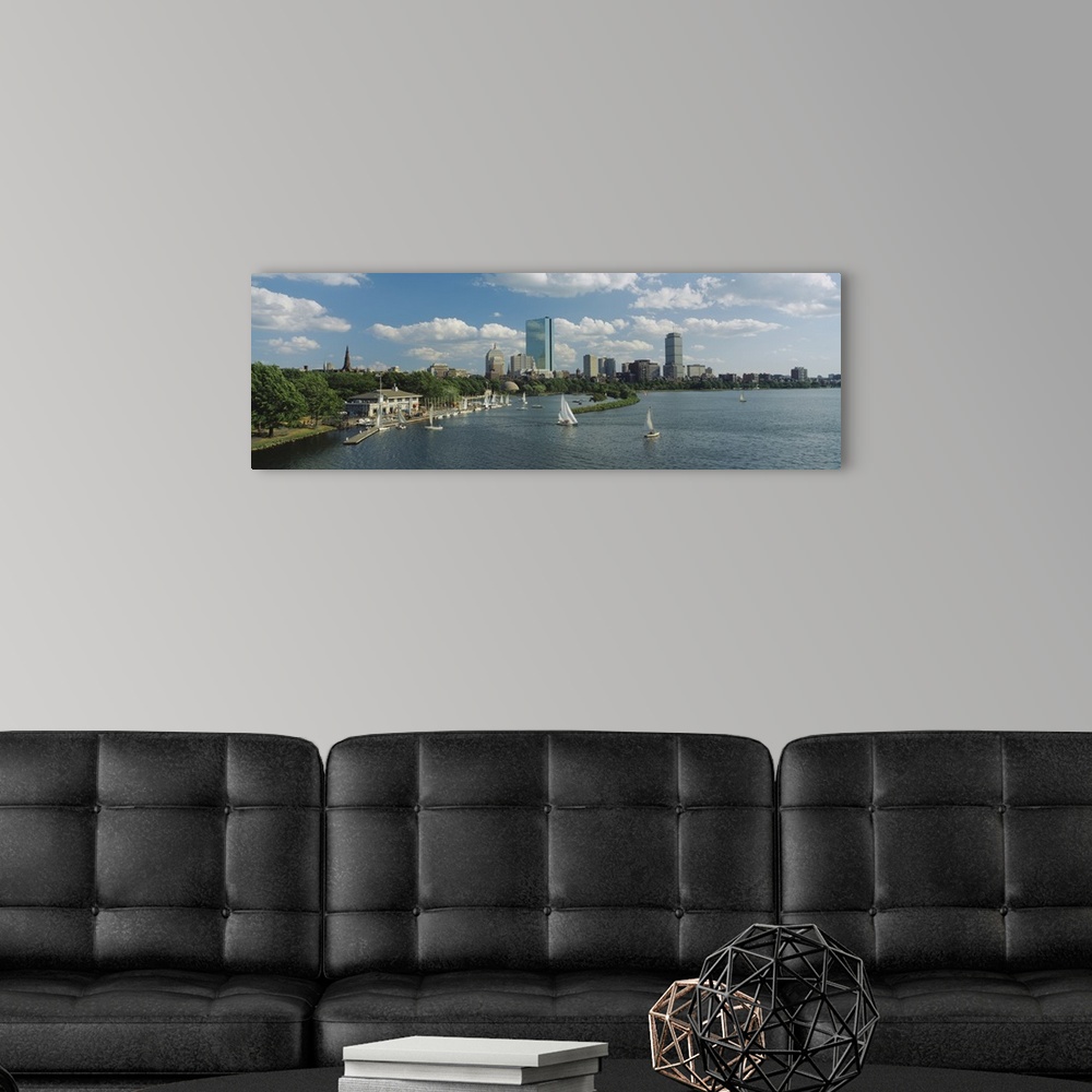 A modern room featuring A panoramic photograph of Charles river with sail boats and the Boston skyline in the background....