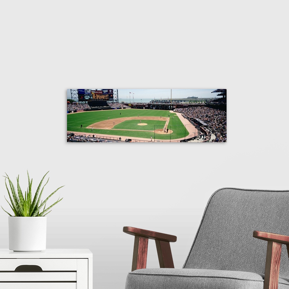A modern room featuring This decorative wall art is a panoramic canvas of a baseball stadium in the middle of a game.