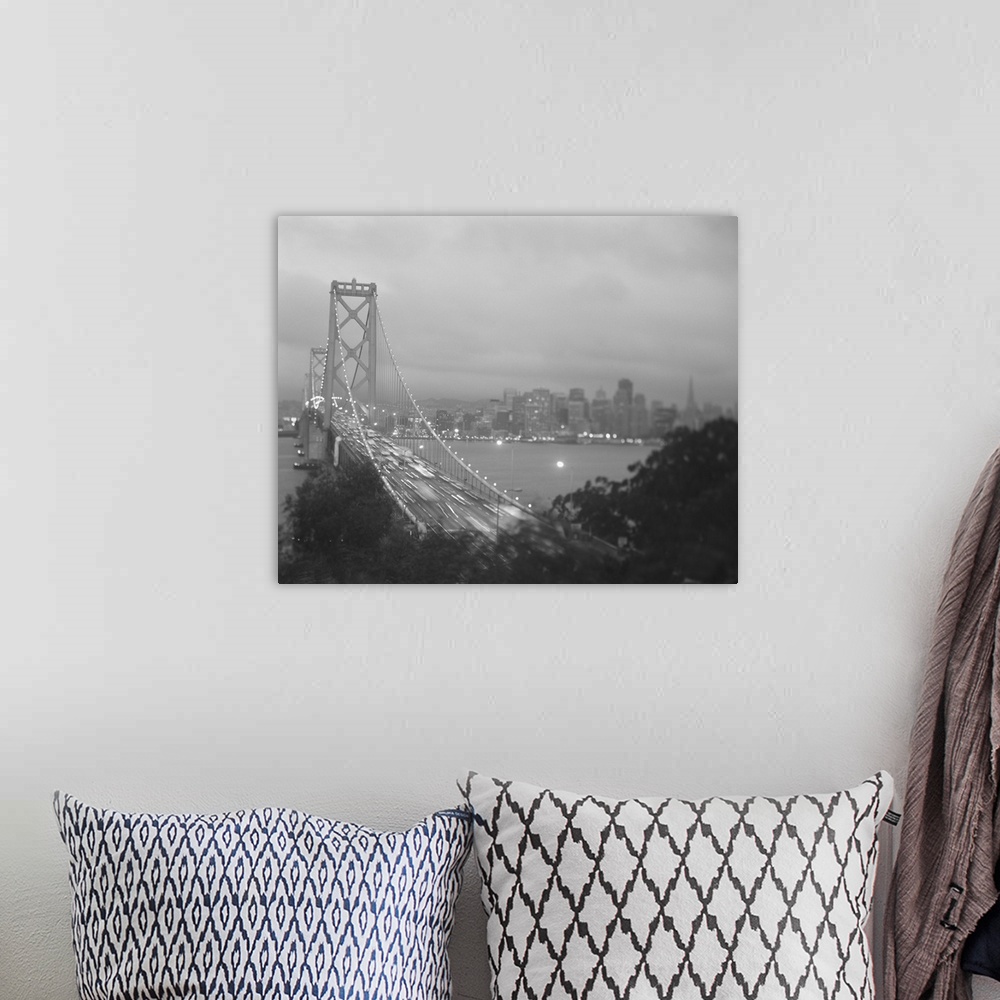 A bohemian room featuring This photograph is of the golden gate bridge lit up at night with the cars lights streaking by an...