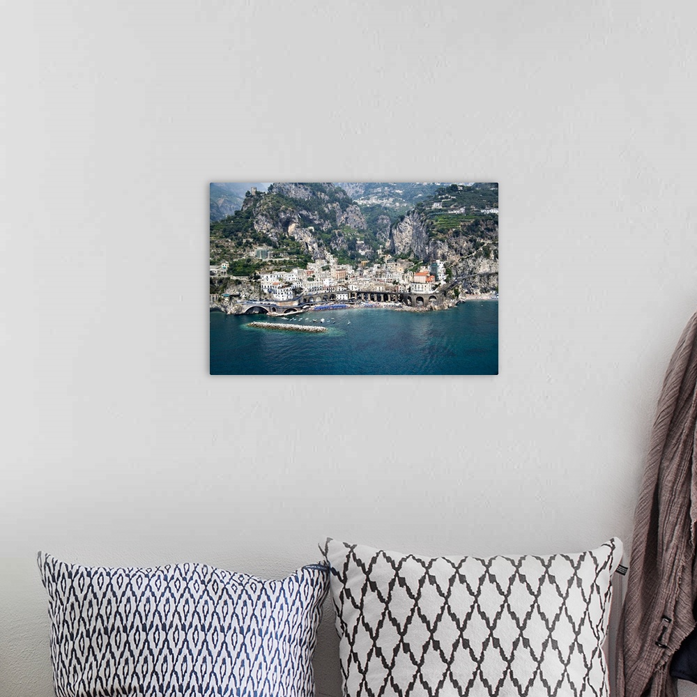 A bohemian room featuring This decorative wall art is an aerial photograph of an Italian village and harbor build into stee...