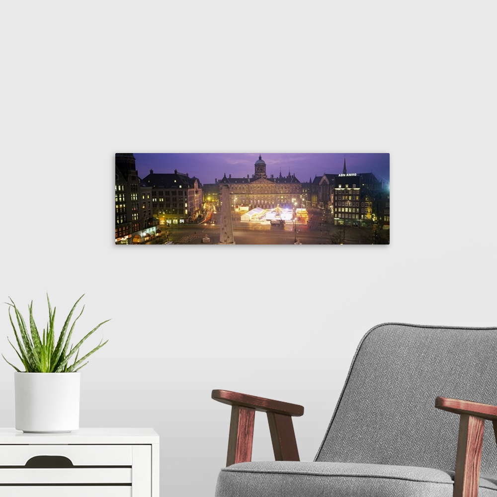 A modern room featuring High angle view of a town square lit up at dusk, Dam Square, Amsterdam, Netherlands